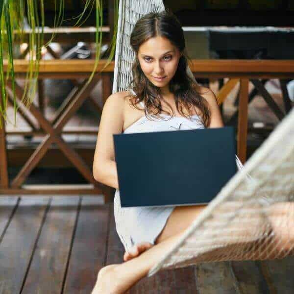 Webseiten Wartung Frau sitzt mit Laptop in Hängematte